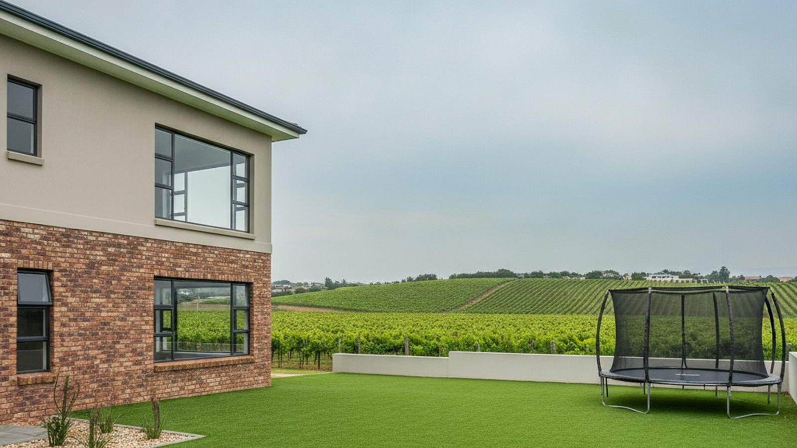 Artificial grass lawn at a Durbanville family home with vineyard hills behind